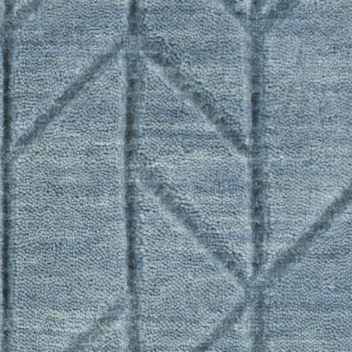 Blue-gray rug with geometric diamond pattern and plush loop-pile texture.