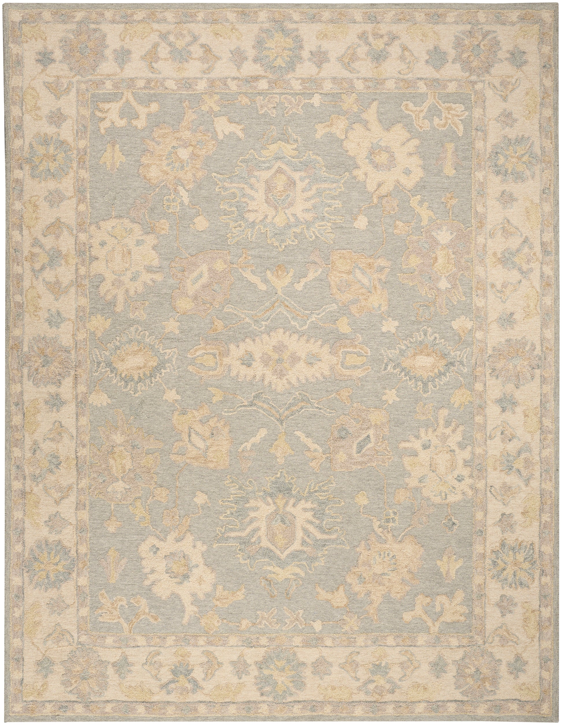 Pastel blue area rug with ivory floral medallions and a pale beige ornate border; vintage distressed style.