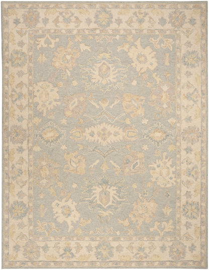 Pastel blue area rug with ivory floral medallions and a pale beige ornate border; vintage distressed style.