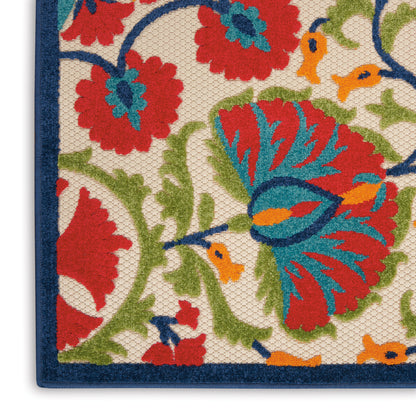 Close-up of a woven floral rug with red, blue, green and orange blossoms on beige, dark blue border.