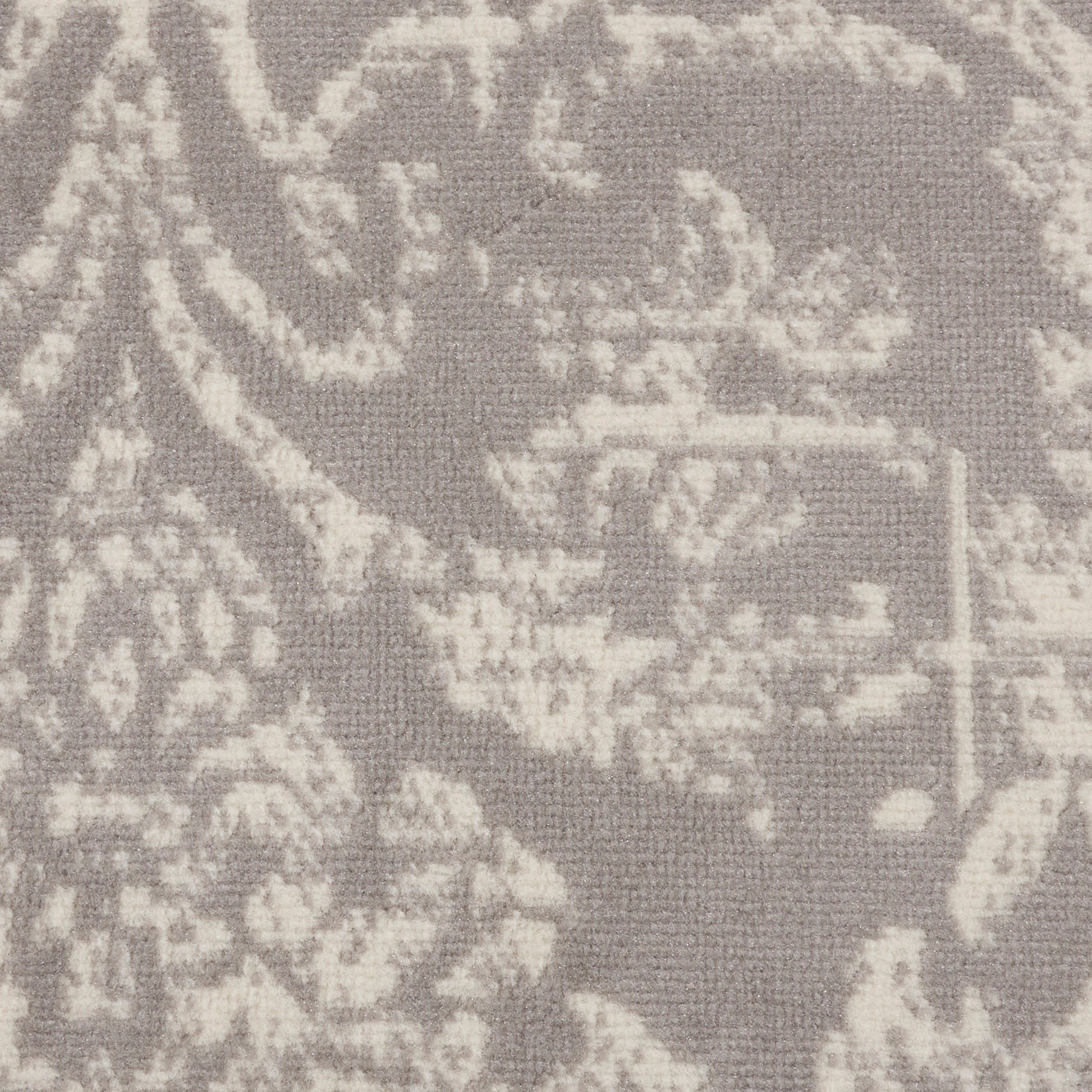 Soft grey damask patterned rug with a pale ivory floral motif; round 5' diameter vintage-style rug.