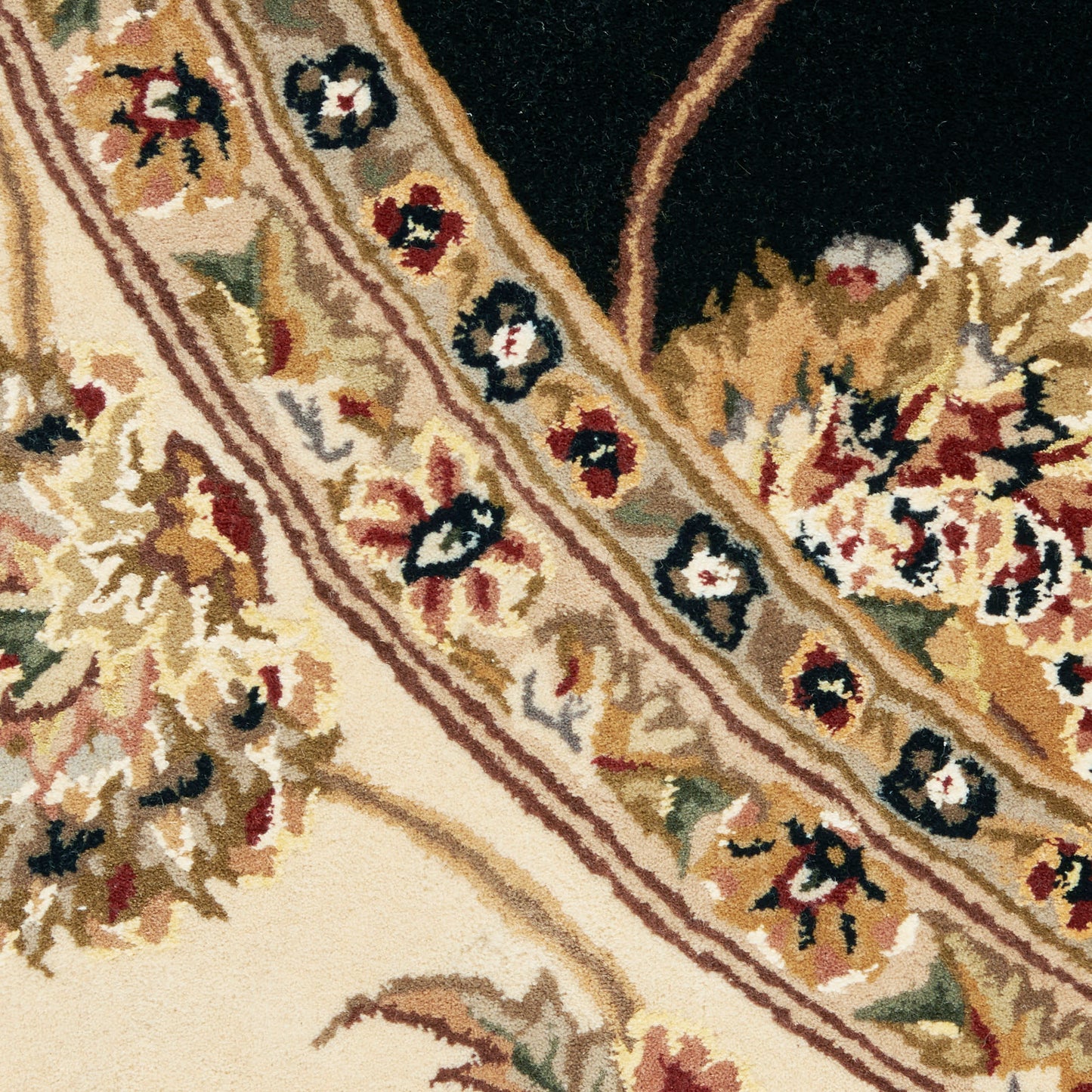 Close-up of a beige floral rug with an ornate border and cream field, featuring red, black, gold and green flowers.