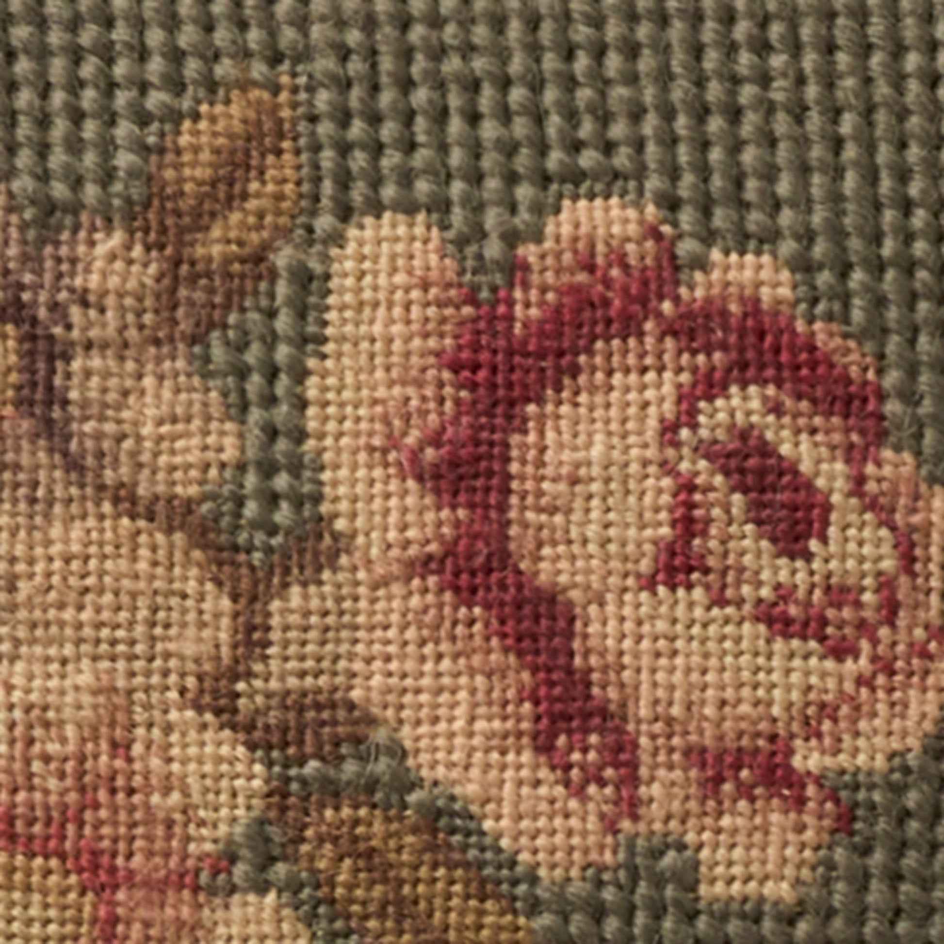 Close-up of a woven floral design: pink rose with beige petals, brown stems, on a muted gray-green background.