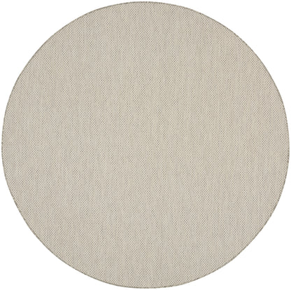 Beige circular fabric speaker grille with fine perforated texture.