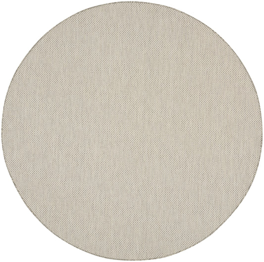 Beige circular fabric speaker grille with fine perforated texture.