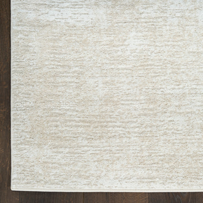 Cream textured area rug with plush pile on dark wood floor; rectangular, neutral-toned.