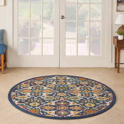 Circular Bohemian-style woven rug with navy border and red, gold, teal floral pattern in an entryway.
