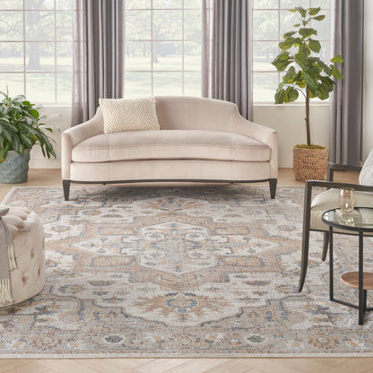 Beige-blue patterned vintage rug (8' x 10') on a sunlit living room floor.