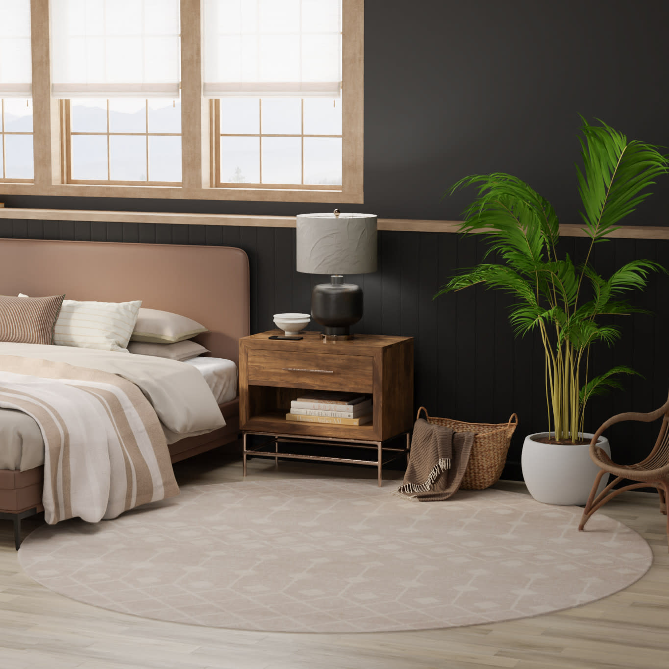 Soft beige round area rug in a modern neutral bedroom with a blush upholstered bed, wooden nightstand, black lamp, and plant.