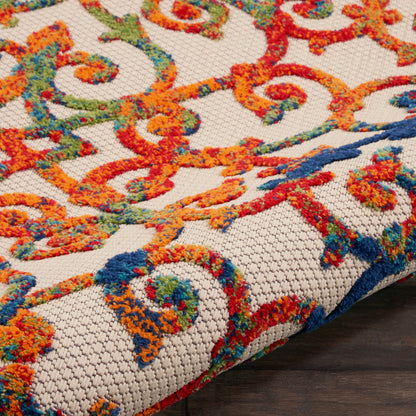 Colorful woven rug with swirling orange, red, blue and green patterns on beige base; chunky textured boucle weave.