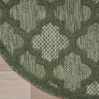 Muted sage-green round rug on a wooden floor.
