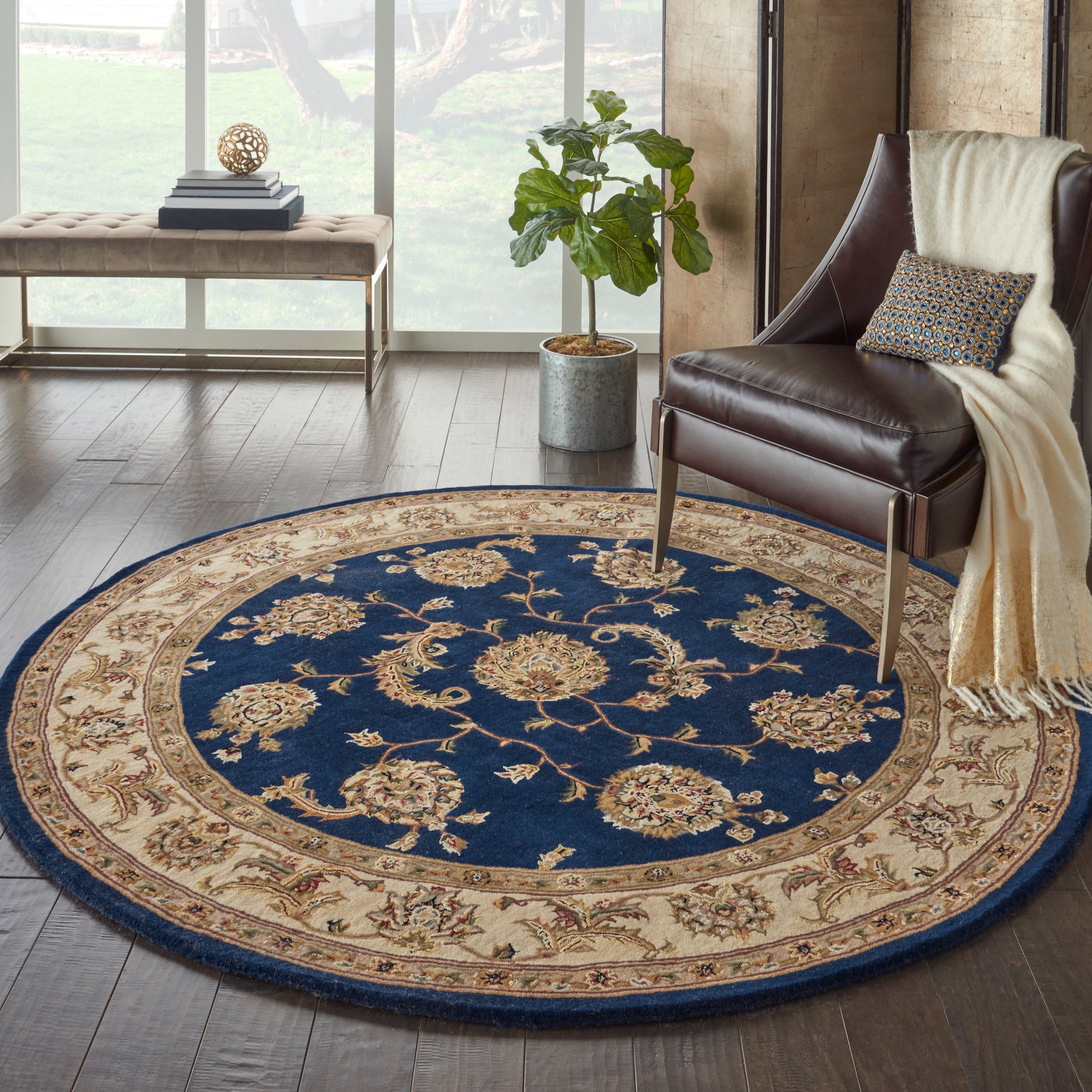 Round blue and beige ornate rug with floral medallions in a modern living room beside a leather armchair.