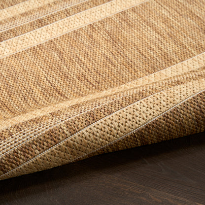 Natural jute rug with beige and tan stripes; textured woven surface on dark wood floor.