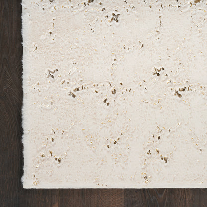 Cream textured rectangular rug with soft shag pile and gold metallic flecks on dark wood floor.