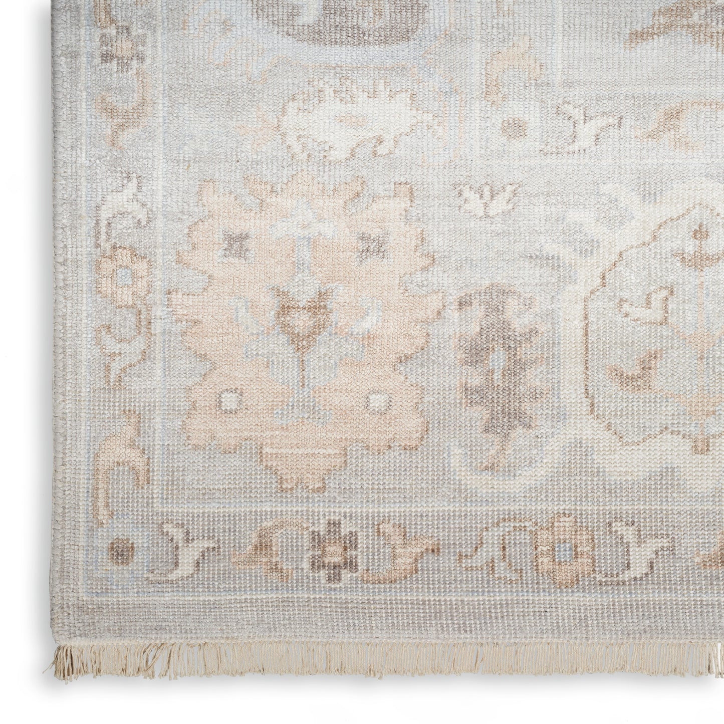 Soft gray-beige oriental rug with floral motifs and fringe.