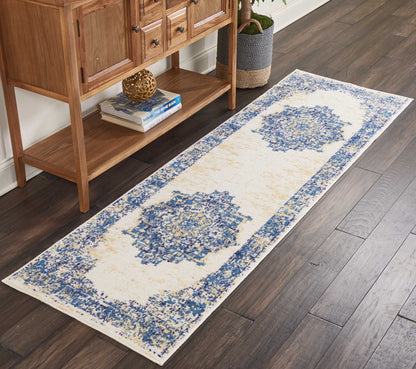 Ivory hall runner rug with blue medallion pattern and blue border, laid along dark wood floor beside a wooden console.
