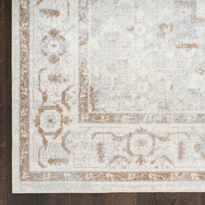 Distressed beige and gray oriental area rug with tan ornamental border on dark wood floor.