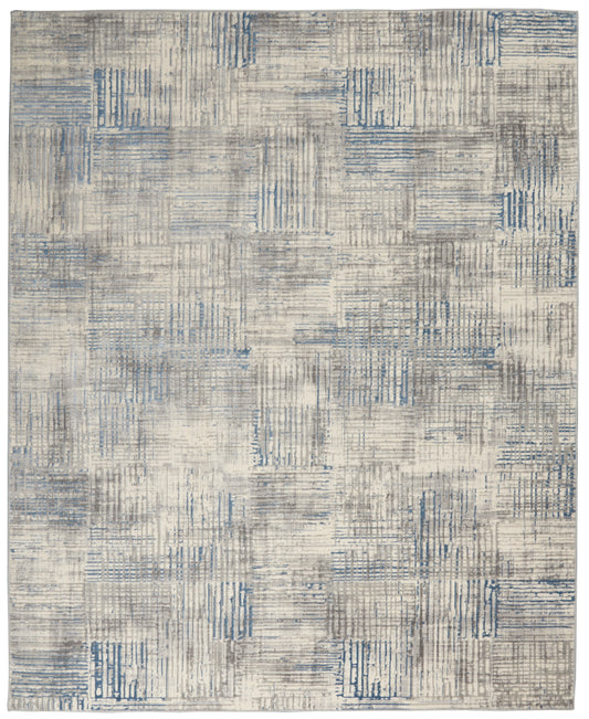 Blue-gray patchwork area rug with distressed linear block patterns in beige tones.