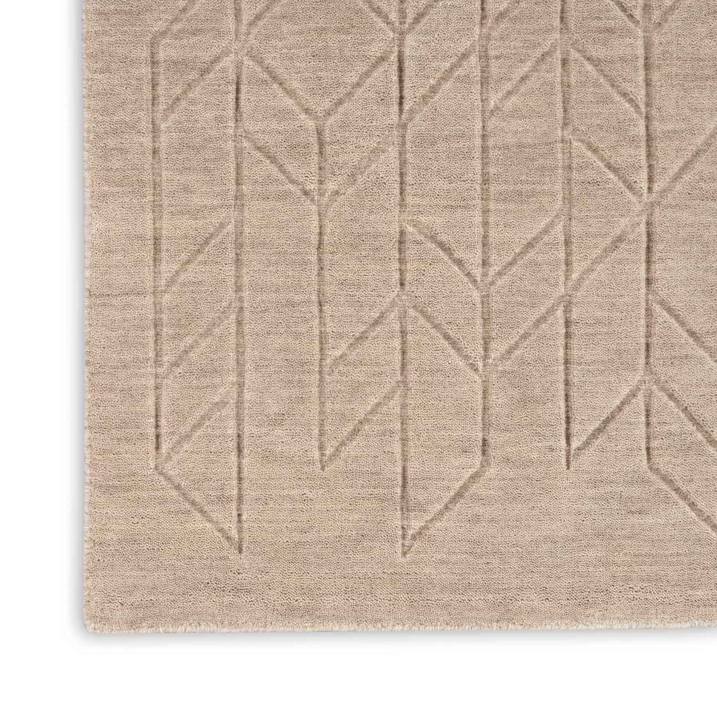 Beige woven rug featuring a geometric chevron/tree-branch stitch pattern and a textured surface.