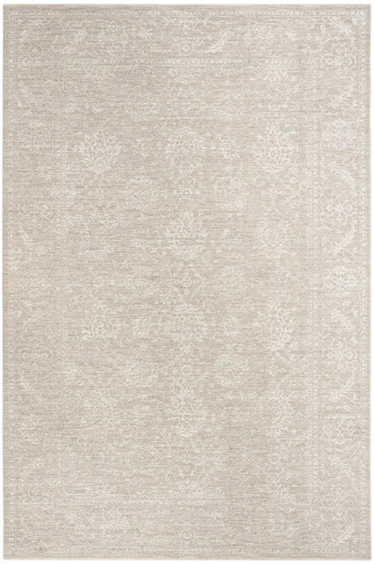 Neutral beige area rug with faded ivory floral medallions and decorative border, vintage-inspired.