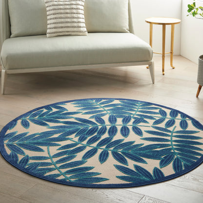 Round rug, 5 ft diameter, blue tropical leaf pattern on beige background in a bright living room