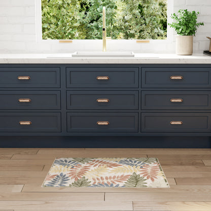 Dark blue kitchen base cabinets with brass handles, white countertop, gold faucet, leafy-pattern rug on wooden floor.
