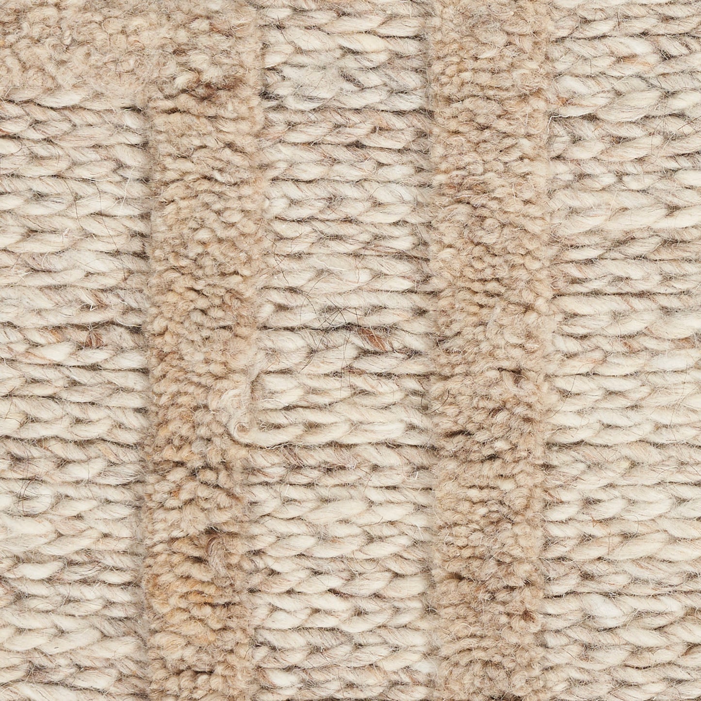 Beige woven rug close-up with chunky looped fibers and vertical tan stripes.