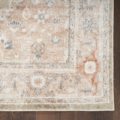 Vintage-inspired peach-beige rug with blue floral pattern and pale border on wood floor.
