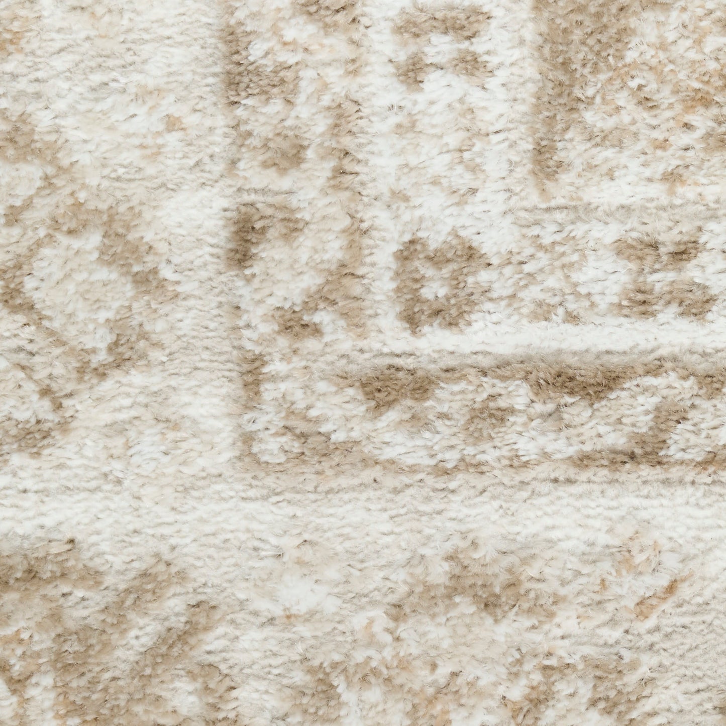 Cream-tan plush shag rug with a subtle geometric pattern; soft, textured surface for cozy living room decor.