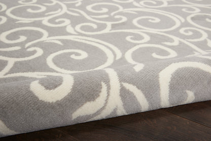 Gray rug with white scrolling pattern, plush texture on dark wood floor; modern decorative area rug.
