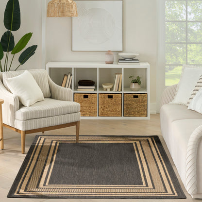 Neutral living room with white cubby shelf, woven baskets, beige striped armchair, dark gray rug with tan border.
