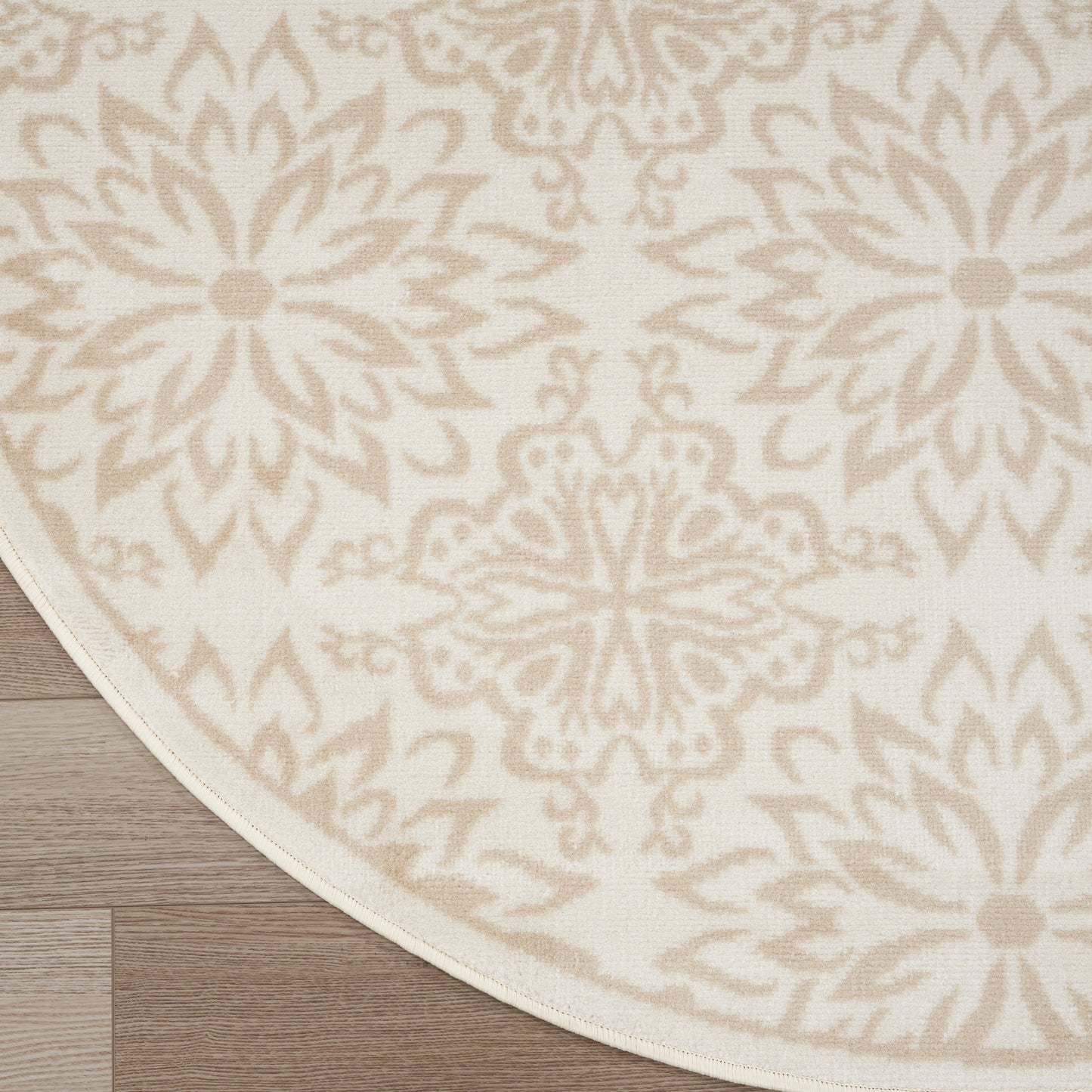 Round cream rug with light beige damask medallion pattern and pale border; decorative, soft floor covering.