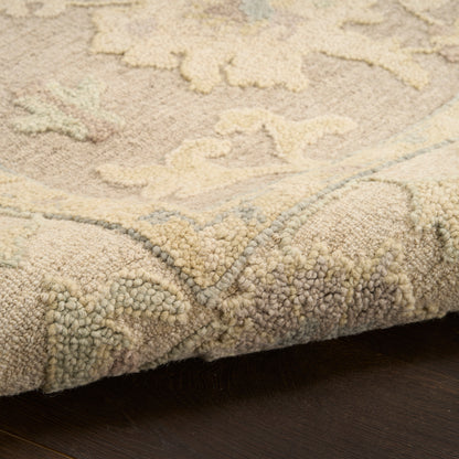 Beige rug close-up with soft loop pile, cream and pale blue floral pattern and rolled edge.