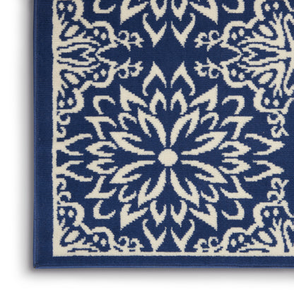 Blue rug corner with white mandala-style floral pattern and navy border.