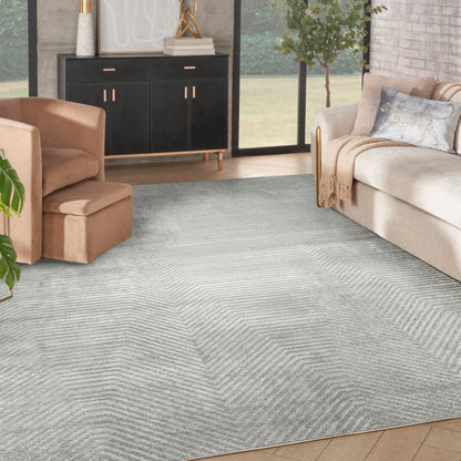 Light gray textured rug with chevron pattern in a modern living room with beige sofa and black sideboard.