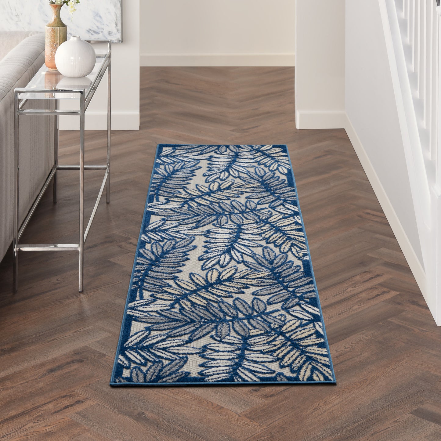 Blue and ivory fern-print runner rug on wood floor; slim rectangular, modern coastal hallway décor