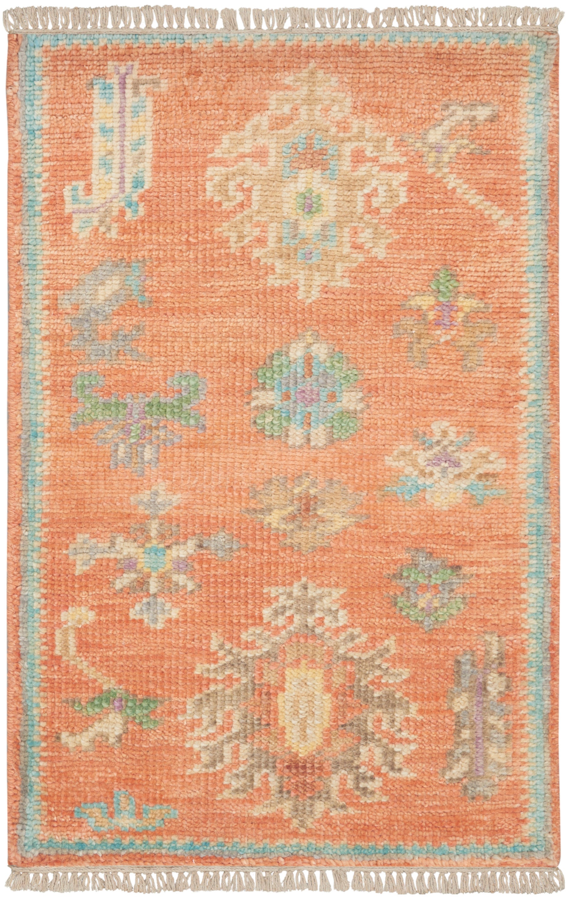 Rectangular orange wool rug with pastel floral/medallion motifs, ivory, blue and green accents; blue border and fringe.