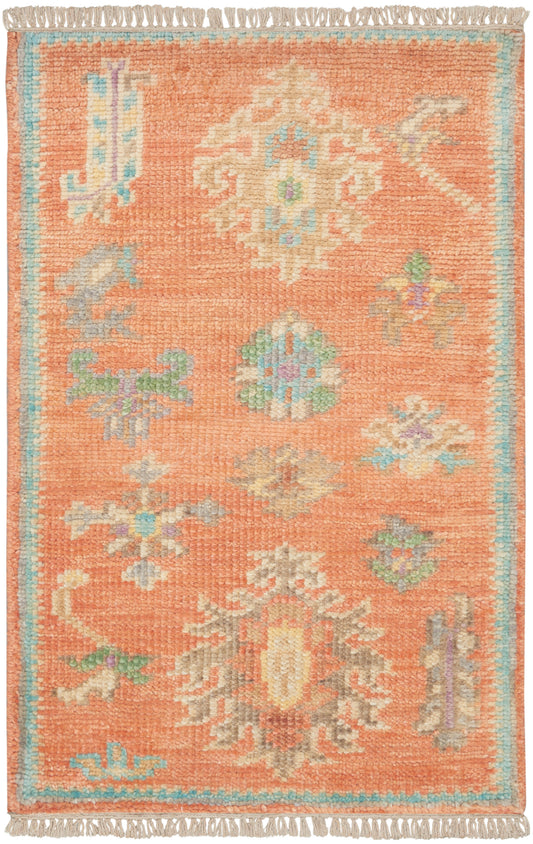 Rectangular orange wool rug with pastel floral/medallion motifs, ivory, blue and green accents; blue border and fringe.