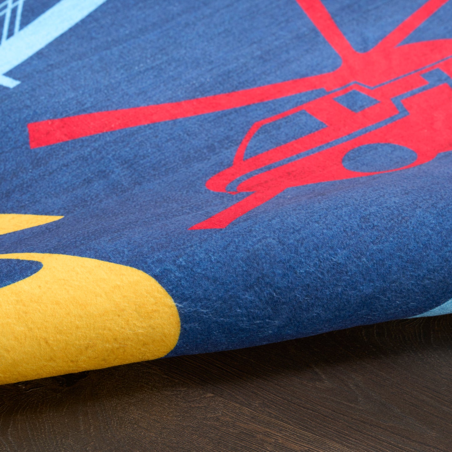 Blue kids rug with red helicopter graphic and yellow accents, soft pile, 7' x 9'.