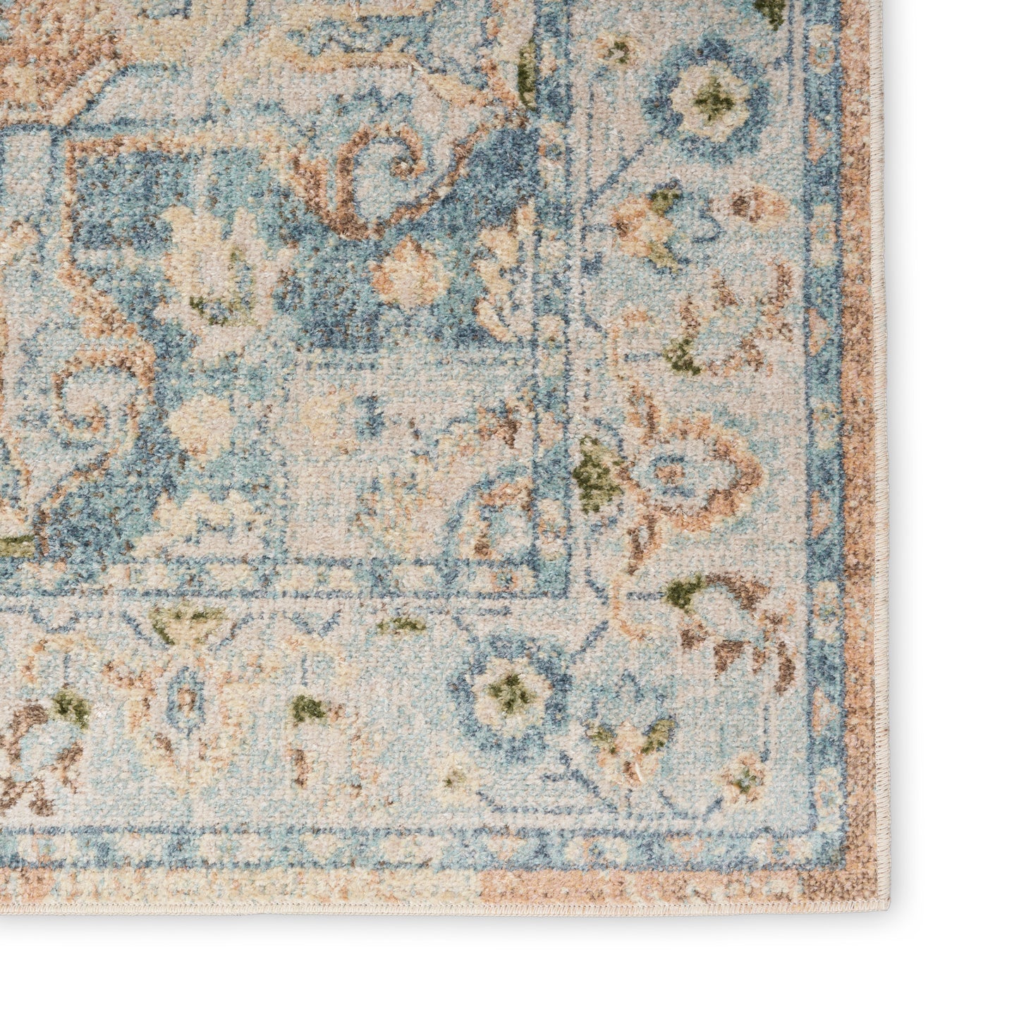 Distressed blue & ivory Persian-style rug corner with floral border & subtle peach accents.