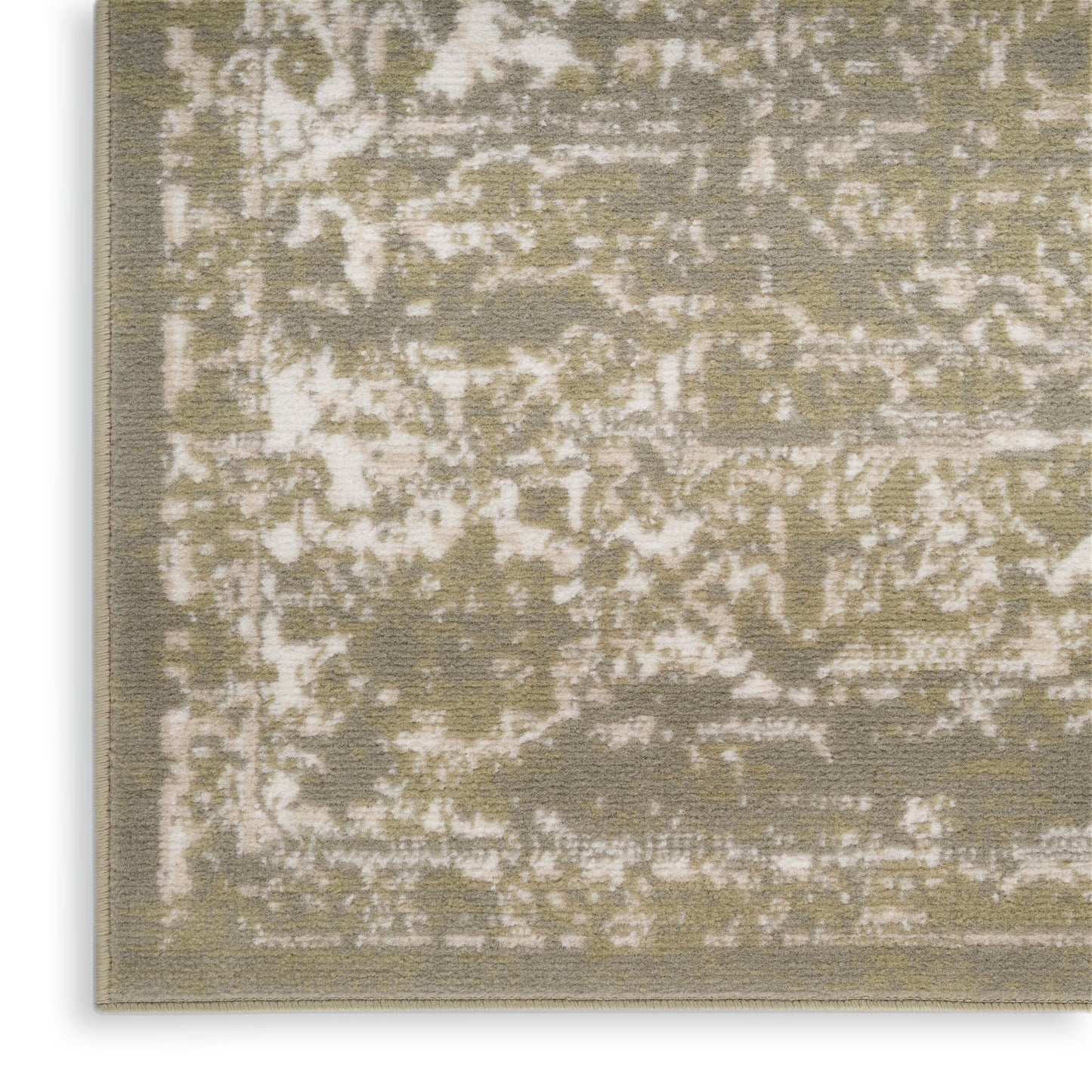 Close-up of an olive and beige distressed patterned area rug with woven texture and bound edge.