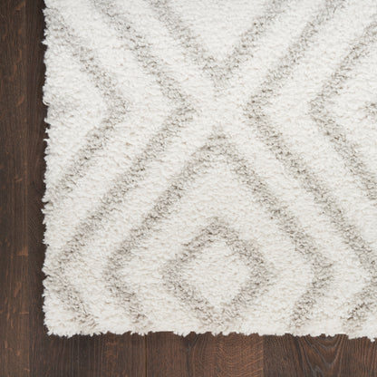 Cream shag rug with light gray diamond geometric pattern on dark wood floor.