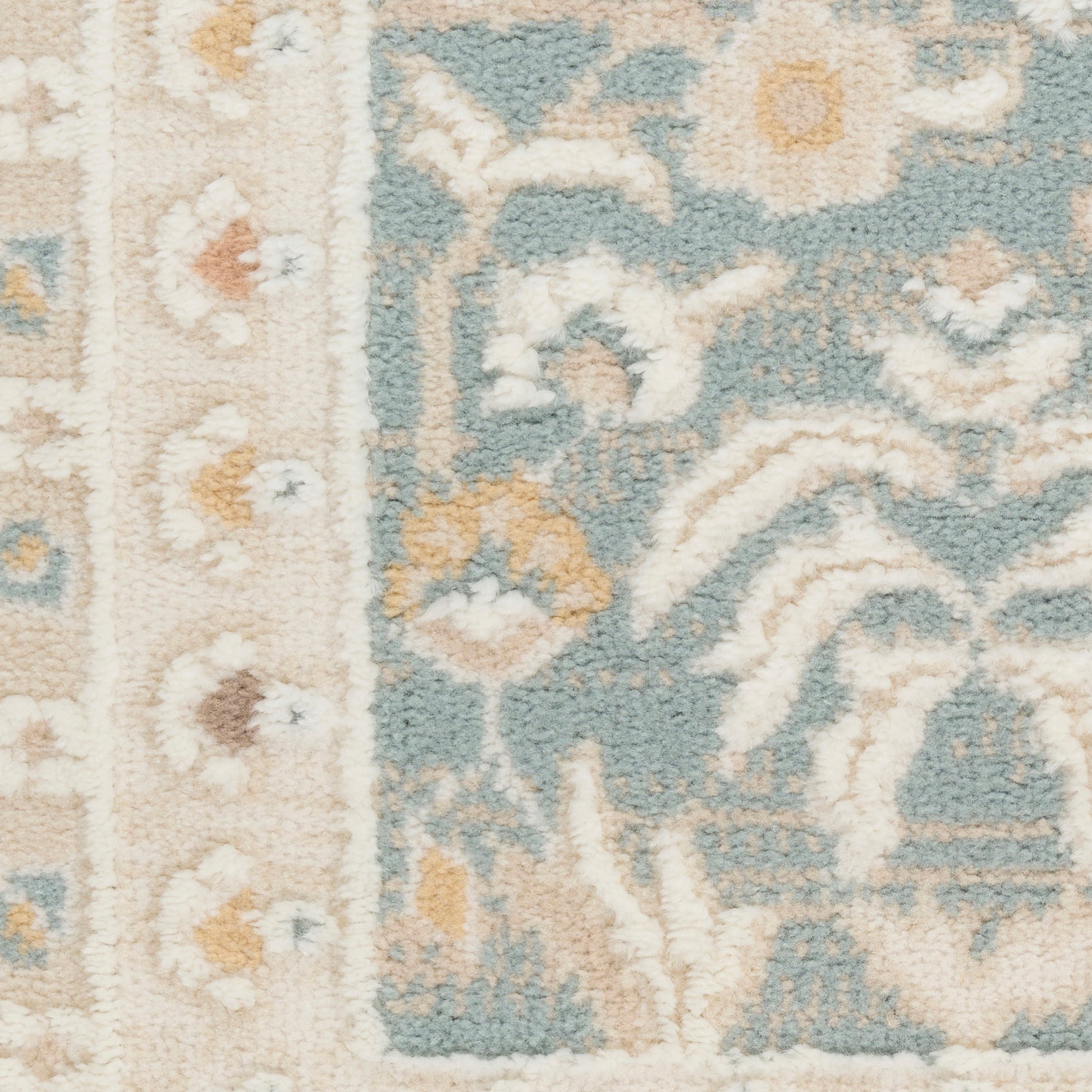 Soft woven rug with teal field, ivory border, cream floral motifs; traditional oriental-inspired pattern.