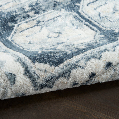 Blue and white geometric shag rug with thick plush pile on dark wood floor.