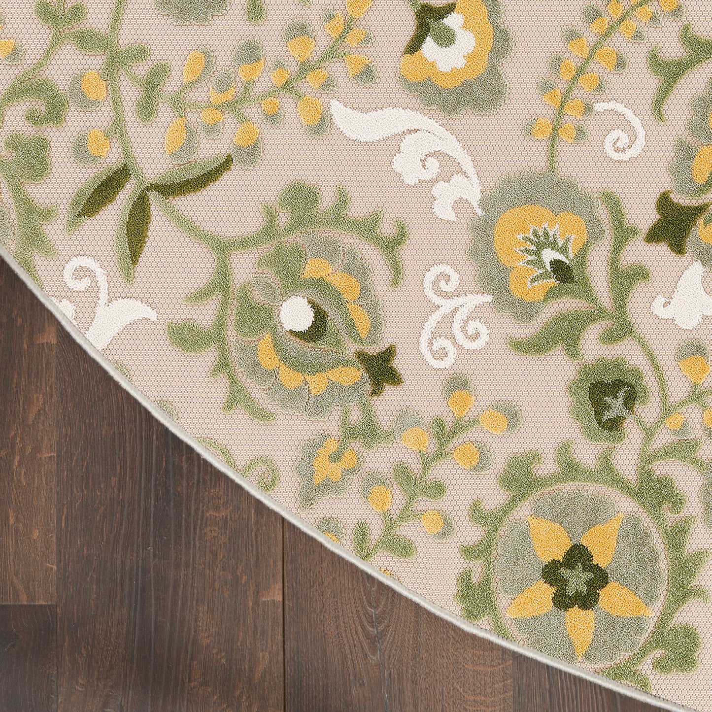 Round beige outdoor rug with oriental floral pattern in green and yellow.