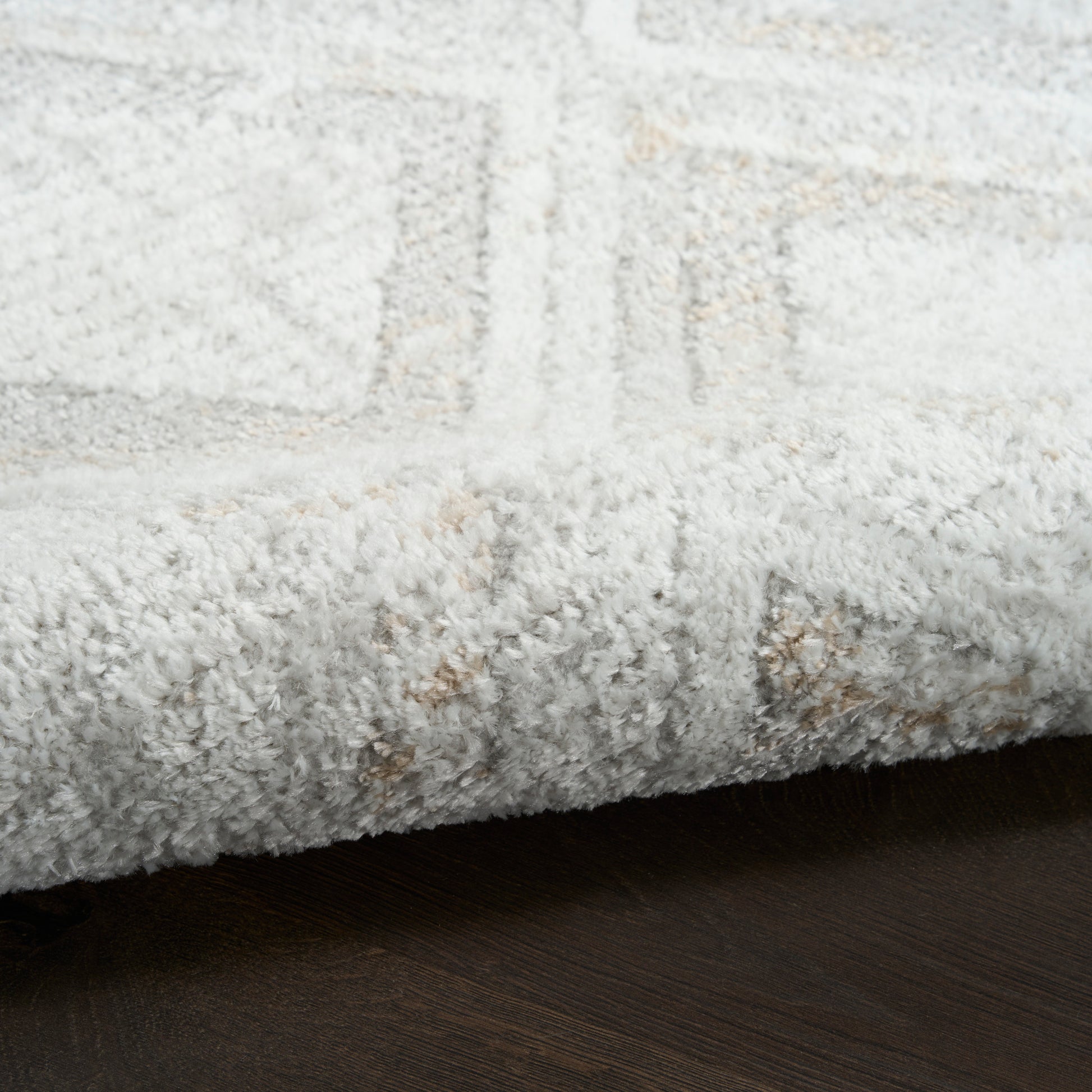 Cream rug with a subtle geometric pattern on a dark wood floor, 8' x 10'.