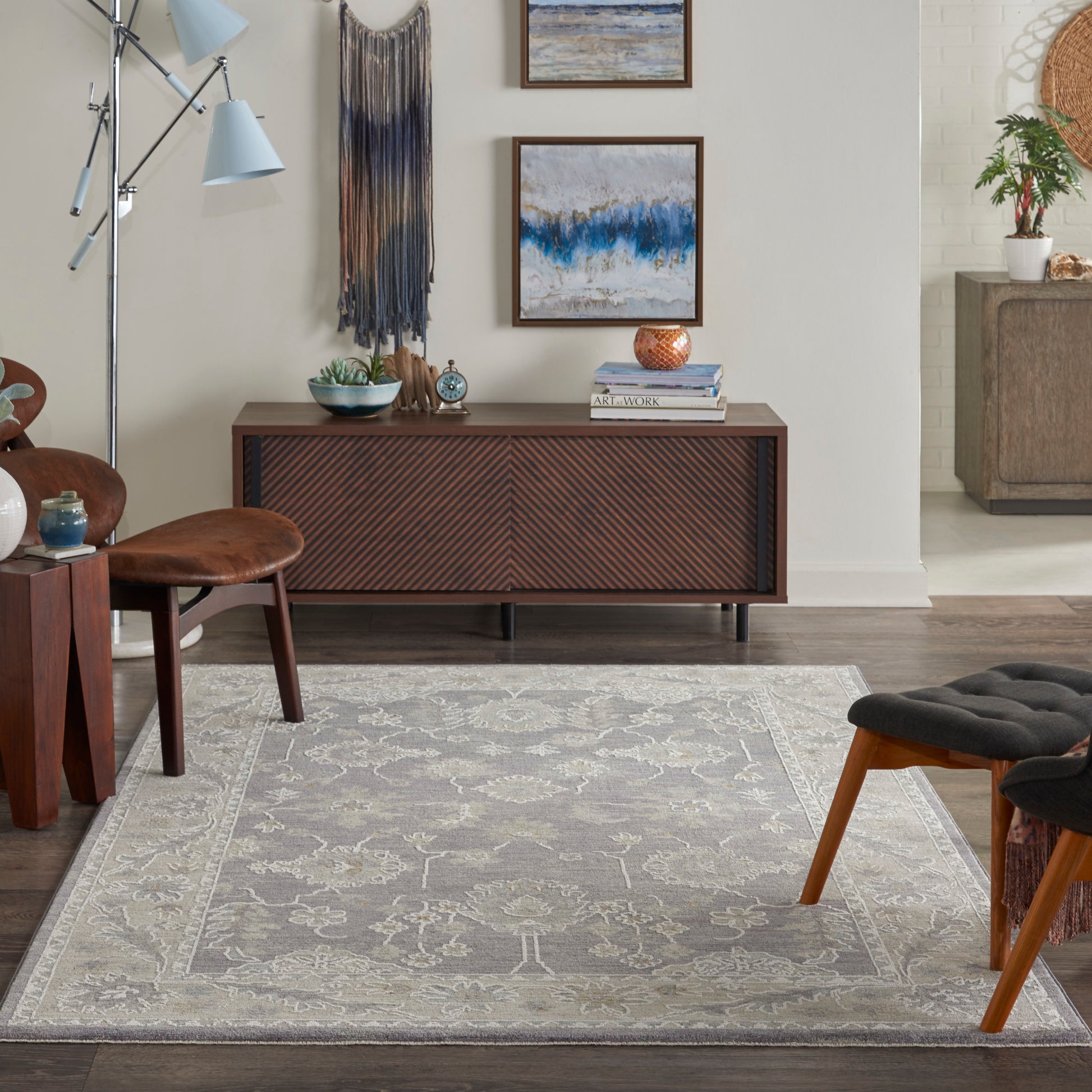 Grey patterned area rug with a light beige border on a wood floor in a mid-century modern living room setting.