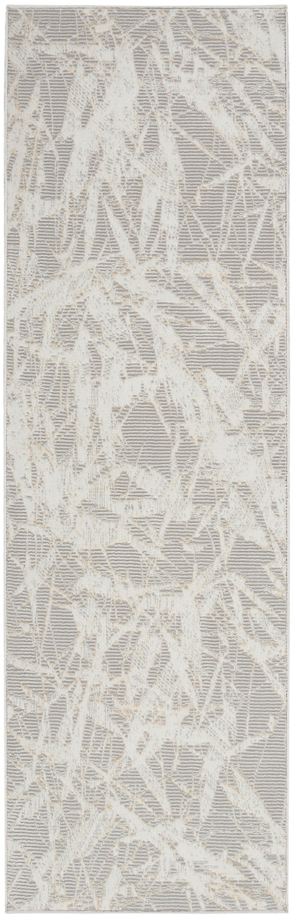 Rectangular area rug in cream and taupe with abstract branch-like pattern and soft textured pile.