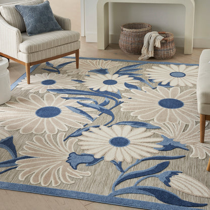 Rectangular rug with large white daisies, blue stems and centers on beige background in a cozy living room.