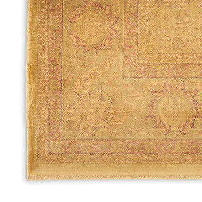 Golden yellow Oriental area rug with pink floral borders and fringed edges, rectangular.
